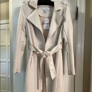 Cream coat with tags on, zip pockets and sleeves